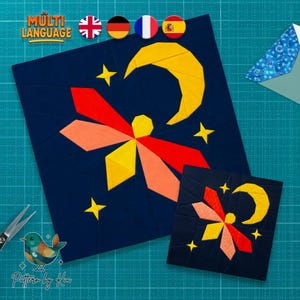May include: A square fabric quilt block featuring a dark navy blue background with a central firefly design in red, orange, and yellow. A large yellow crescent moon and several small yellow stars are positioned around the firefly. A smaller version of the same design is placed in the bottom right corner.