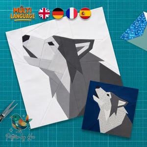Può includere: Un blocco per trapunta quadrato con una testa di lupo geometrica che ulula, resa in tonalità di bianco, grigio chiaro e grigio scuro. Una versione più piccola dello stesso disegno del lupo è mostrata in toni blu, bianchi e grigi accanto.