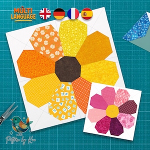 Może przedstawiać: Kolorowy blok patchworkowy w kształcie słonecznika z tkaninami w pomarańczowym, żółtym i brązowym kolorze. Widoczna jest również mniejsza wersja bloku. Obraz zawiera tekst "MULTI LANGUAGE" i logo z ptakiem.