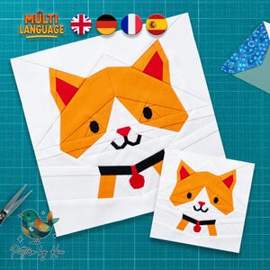 May include: Two white fabric squares with orange and red cat faces. The larger square has a black collar with a red tag. The image includes the text "MULTI LANGUAGE" and the text "Pattern by Kia".