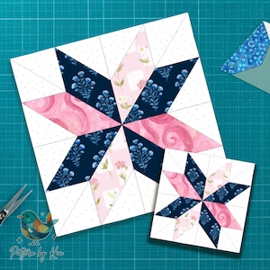 Puede incluir: Dos bloques de edredón en forma de estrella, uno grande y otro pequeño, con patrones florales blancos, rosas y azul marino. Los bloques están sobre una esterilla de corte verde azulado. Unas tijeras y un pequeño logotipo de pájaro están en la imagen.