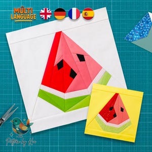 Op de afbeelding: Een stoffen quiltblok met een samengesteld watermeloenontwerp in rood, roze, wit en groen op een witte achtergrond, naast een kleiner geel quiltblok met een soortgelijke watermeloen en de tekst MULTI LANGUAGE.