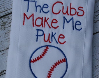Può includere: Coperta per bambini bianca con testo ricamato blu e rosso che recita "The Cubs Make Me Puke" e una grafica di baseball. La palla da baseball è blu con cuciture rosse.