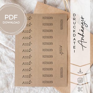 Könnte beinhalten: Ein Bogen Kraftpapier mit mehreren rechteckigen Etiketten, auf denen die Wörter "PUSTEKUCHEN" und "puste kuchen" in einer handschriftlichen Schriftart gedruckt sind. Die Worte "PDF DOWNLOAD" befinden sich in einem Kreis in der oberen linken Ecke. Das Wort "Anhänger" steht vertikal rechts.