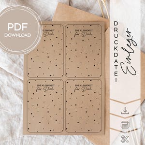 Könnte beinhalten: Ein Bogen mit vier Geschenk-Anhängern aus Kraftpapier mit abgerundeten Ecken, die jeweils den Text "EINE KLEINIGKEIT für Dich" und verstreute schwarze Punkte tragen. Die Worte "PDF DOWNLOAD" befinden sich in einem Kreis oben links.