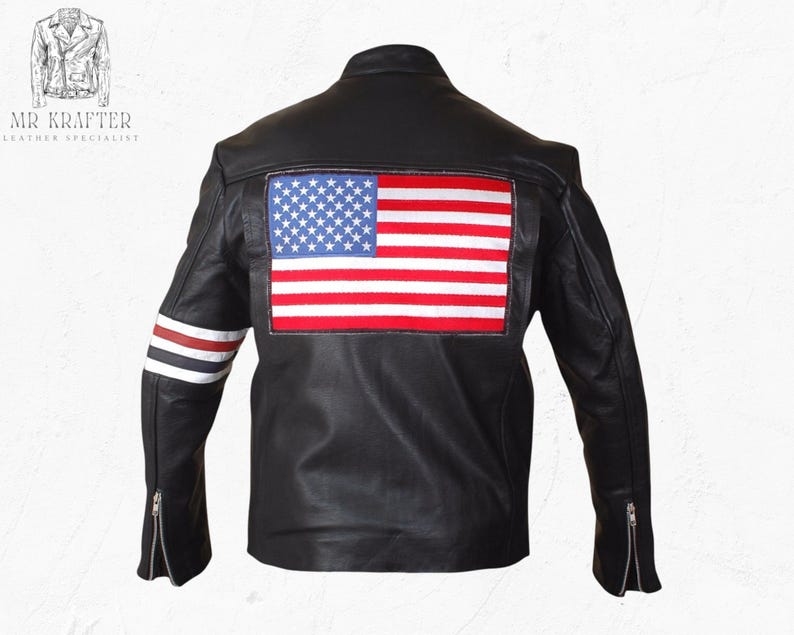 May include: Black leather jacket featuring an American flag patch on the back. The jacket has a classic biker style with a zip-up front, zippered sleeves, and red, white, and blue stripes on the left sleeve. The jacket is a leather specialist product.