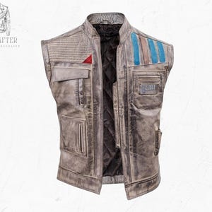 Puede incluir: Un chaleco de cuero gris desgastado con múltiples bolsillos y un forro negro acolchado. Cuenta con un acento rojo y rayas azules y marrones en el hombro. El chaleco tiene un aspecto vintage y desgastado.