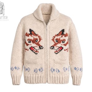 May include: Cream-coloured, zip-up cardigan sweater with two embroidered fox faces. The sweater has a shawl collar, two front pockets, and blue and white floral accents near the bottom. The sweater is made of a thick, textured knit.