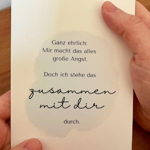 Könnte beinhalten: Eine weiße Karte mit deutschem Text in schwarzer Schrift. Der Text lautet: "Ganz ehrlich: Mir macht das alles große Angst. Doch ich stehe das zusammen mit dir durch." Die Karte wird von einer Hand gehalten.