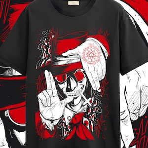 May include: Black t-shirt featuring a red and white graphic of a character with a hat, sunglasses, and a cross. The character's hand displays a red pentagram tattoo. The design has a bold, comic book style.