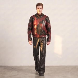 Pode incluir: Um casaco com um padrão geométrico em vermelho escuro e preto, fecho de correr frontal e gola alta, combinado com calças pretas lisas. O conjunto apresenta um acabamento liso e mangas compridas, criando um visual coerente.