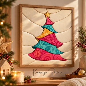 May include: A square framed wall art piece featuring a Kinusaiga pattern of a stylized Christmas tree. The tree is composed of layered fabric sections in shades of pink, teal, and yellow with various floral and circular prints, topped with a gold star.