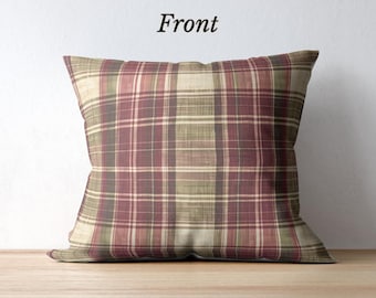 May include: Square pillow with a plaid pattern in shades of burgundy, olive green, and beige. The word "Front" is printed in black at the top of the pillow. The pillow is resting on a wooden surface.