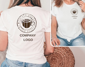 May include: White t-shirt featuring a brown coffee cup logo with the text "COFFEE HOUSE" and "COMPANY LOGO" in a circular design. The shirt is a crew neck style.