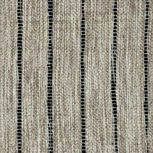 May include: A woven fabric featuring a textured, light brown and beige surface with a prominent vertical striped pattern. The design consists of alternating wide, coarse-textured tan bands and thin, dark black vertical lines spaced evenly throughout.