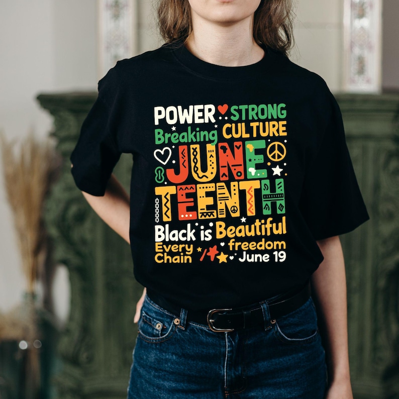Może przedstawiać: Czarny t-shirt z kolorowym wzorem graficznym. Projekt zawiera słowa "POWER", "JUNE TEENTH" i "Black is Beautiful". Koszulka zawiera r&oacute;wnież serca, gwiazdy i inne symbole. Tekst "June 19" jest r&oacute;wnież uwzględniony.