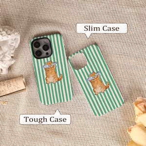 May include: Two phone cases, one assembled and one disassembled, with a green and white striped pattern. Each case features a cartoon cat wearing sunglasses and holding fish. The text "Slim Case" and "Tough Case" are also visible.