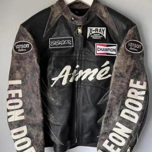 May include: Black leather motorcycle jacket with distressed accents. Features patches with "X-RAY", "CHAMPION", and "Aim&eacute;" text. Sleeves display "LEON DORE" in white lettering. Includes "Vanson Leathers" patches.