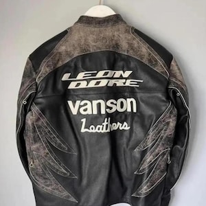 May include: Black leather jacket with the text "LEON DORE" and "Vanson Leathers" in white. The jacket has distressed brown accents on the shoulders and decorative stitching.