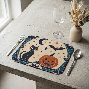 Peut inclure: Un set de table rectangulaire avec un fond crème et un motif d'Halloween bleu foncé et orange. Le design présente un chat noir, une citrouille orange sculptée, un croissant de lune bleu foncé, une chauve-souris et des petites étoiles.