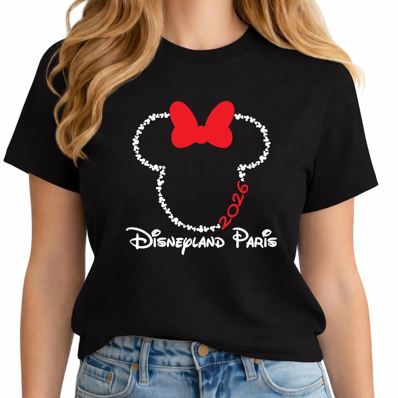 May include: Black t-shirt featuring a Minnie Mouse design made of white hearts, a red bow, and the text "2026 Disneyland Paris" in white. The design is centered on the front of the shirt.