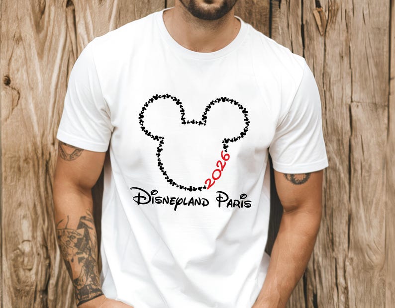 May include: White t-shirt featuring a black Mickey Mouse head outline made of small hearts. The number "2026" is in red, and the words "Disneyland Paris" are printed below the graphic in black.