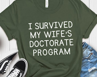 Camiseta "Sobreviví al programa de doctorado de mi esposa", regalo para esposo, camiseta divertida de graduación de doctorado, camiseta de disertación de doctorado, camiseta irónica, camiseta de broma de graduación