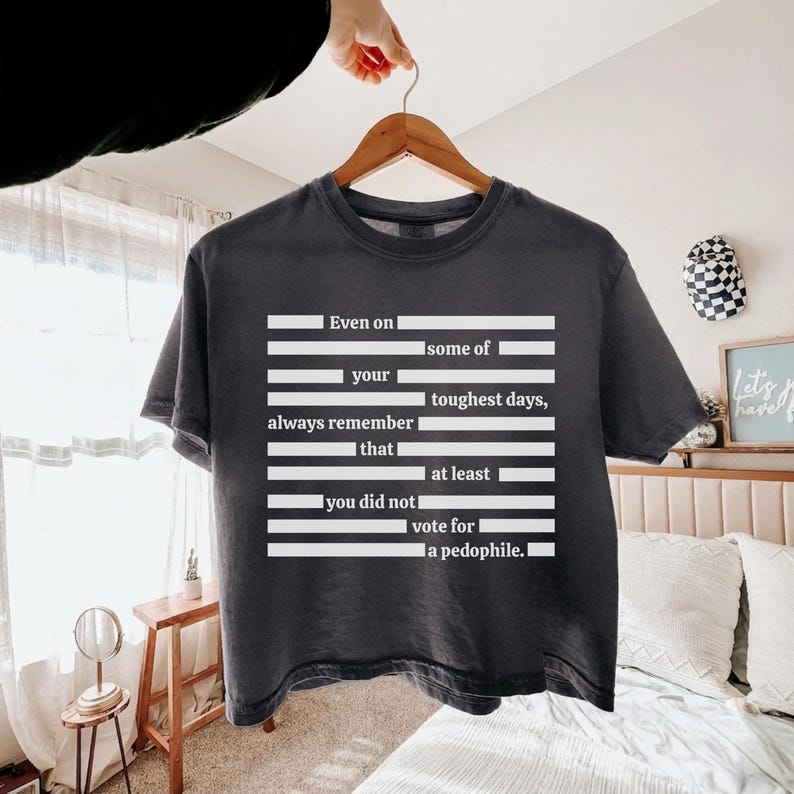 Puede incluir: Camiseta gris oscuro con texto blanco. El texto dice: "Incluso en tus d&iacute;as m&aacute;s dif&iacute;ciles, recuerda siempre que no votaste por un ped&oacute;filo."