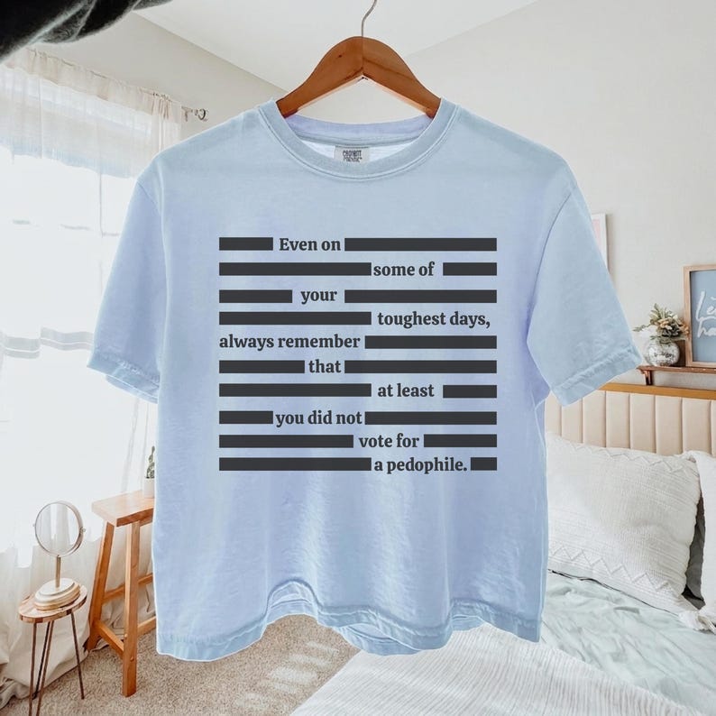 Puede incluir: Camiseta azul claro con un dise&ntilde;o de texto negro. El texto dice: "Incluso en algunos de tus d&iacute;as m&aacute;s dif&iacute;ciles, recuerda siempre que no votaste por un ped&oacute;filo."