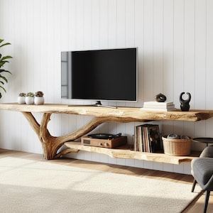 May include: A natural wood TV unit with a live edge design, featuring a lower shelf and a built-in record player. The unit supports a flat-screen TV and is complemented by a potted plant and decorative items, creating a modern living space.