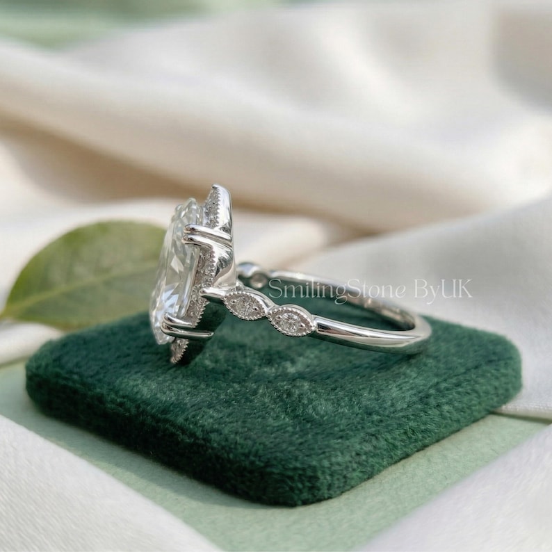 Close up top view of a custom platinum bespoke engagement ring. Flawless symmetry of an F color VS clarity personalized lab grown diamond. The art deco floral halo accentuates its facets. True quiet luxury vibe, fancy cut bridal statement piece, premium platinum statement, bespoke bridal gem, luxury promise gem, regal bridal piece, brilliant cut gem, and custom heirloom gem.