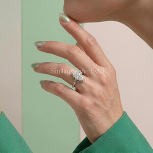 Hand model wearing a custom true to size women's ring. The personalized vintage inspired marquise engagement ring sits elegantly on the finger. This bespoke jewelry offers an affordable luxury feel. Beautiful elongated marquise shape, travel safe gem, handmade UK style, statement piece, dainty thin band solitaire, modern romantic aesthetic, and perfect spring proposal set.