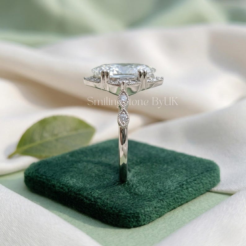 Angled sparkle of a personalized 925 sterling silver custom engagement ring. Brilliant D color VVS1 clarity moissanite catches the light beautifully. Intricate navette shape band enhances this affordable luxury bespoke jewelry. Excellent floral setting gem, nature inspired gem, moissanite bridal set, minimalist dainty detail, vintage bridal set, and sustainable lab gem alternative.
