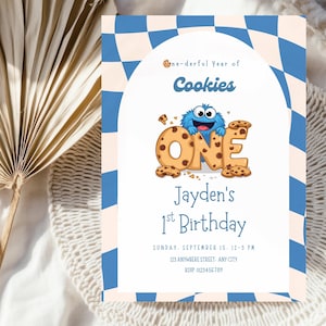 以下が含まれることがあります： 青と白のチェック柄のボーダーが付いた誕生日招待状。「one-derful Year of Cookies」と「Jayden's 1st Birthday」の文字が記載されています。漫画のキャラクターと「ONE」の文字も表示されています。