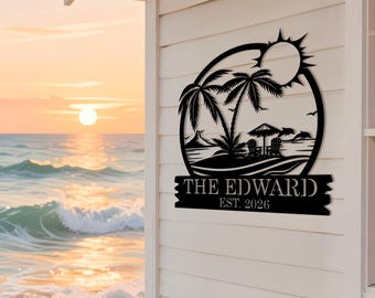 May include: Black metal wall art featuring a beach scene with palm trees, sun, and ocean waves. The art includes the text "THE EDWARD EST. 2026" below the circular design. The art is mounted on a white wall with a sunset in the background.