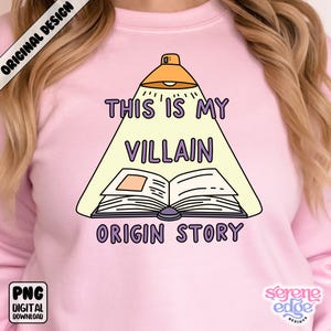 May include: Pink sweatshirt with the text "THIS IS MY VILLAIN ORIGIN STORY" in purple and white. The design features an open book under a spotlight, with the words arranged around it. The sweatshirt also has the text "ORIGINAL DESIGN" and "PNG DIGITAL DOWNLOAD".