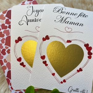 Peut inclure: Cartes de vœux avec un motif de cœur. Une carte dit "Joyeux Anniversaire" et l'autre dit "Bonne fête Maman". Les deux cartes ont un cœur doré au centre et sont décorées de cœurs rouges. L'enveloppe a un motif de cœur.