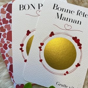 Peut inclure: Cartes de vœux blanches texturées avec les inscriptions « Bon P » et « Bonne fête Maman ». Les cartes comportent un cercle doré bordé de cœurs rouges. L'enveloppe est ornée d'un motif de cœurs rouges et roses.