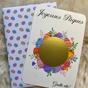 Peut inclure: Carte de vœux sur le thème de Pâques avec un cercle à gratter doré, entouré d'œufs de Pâques colorés et d'éléments floraux. La carte blanche porte les inscriptions "Joyeuses Pâques" et "Gratte vite!". Une enveloppe assortie est incluse.