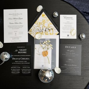 May include: An assortment of wedding stationery, including invitations and response cards, arranged on a dark surface. The invitations feature elegant typography and are accompanied by decorative elements like disco balls and floral accents. The overall aesthetic is modern and sophisticated.
