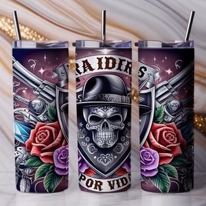 Könnte beinhalten: Edelstahlbecher mit detailliertem Design mit einem Hut tragenden Totenkopf, Revolvern, Rosen und den Worten "RAIDERS POR VIDA". Der Becher hat einen Strohhalm und einen dunkelvioletten Hintergrund.