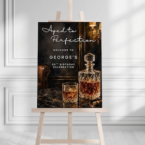May include: Aged to Perfection sign on an easel. The sign welcomes guests to George's 50th birthday celebration. A crystal decanter and a glass of amber liquid sit on a table. The background features a dark, luxurious interior.