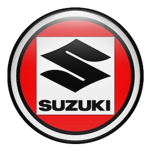 Puede incluir: Logotipo circular y brillante de Suzuki. Presenta un emblema 'S' negro sobre fondo blanco, dentro de un cuadrado rojo. El logotipo está enmarcado por un borde negro y blanco, sobre un fondo blanco.