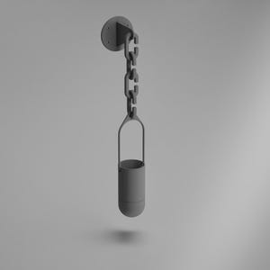 Peut inclure: Un pot de fleurs suspendu gris avec un pot cylindrique suspendu par une chaîne à un support mural circulaire. Le pot a un design minimaliste et convient aux petites plantes ou objets décoratifs.
