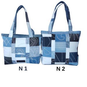 Pu&ograve; includere: Due borse tote in denim con design patchwork. Le borse presentano varie tonalit&agrave; di denim blu, con cuciture decorative. Ogni borsa ha una forma rettangolare e manici robusti. Le borse sono etichettate "N1" e "N2" in basso.