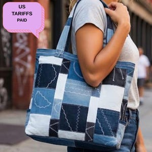 May include: A patchwork denim tote bag with a variety of blue and white denim squares. The bag has sturdy handles and is carried over the shoulder. The bag is made of recycled denim and has a unique, handcrafted look.