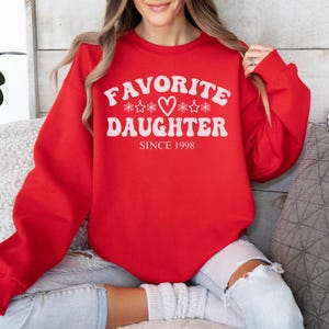 May include: A set of three ceramic nesting bowls. The largest bowl is light blue, the medium bowl is white, and the smallest bowl is a darker blue. Each bowl has a smooth, glossy finish.