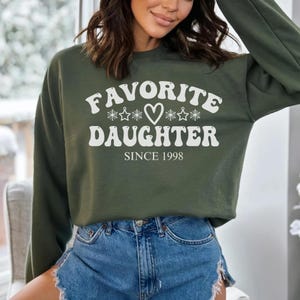 May include: A set of three ceramic mugs with a speckled, matte finish. The mugs are in shades of cream, light gray, and dark gray. Each mug has a simple, minimalist design, perfect for coffee or tea.