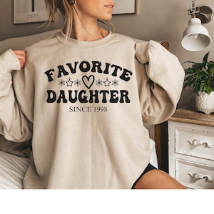 May include: A set of three ceramic mugs with a speckled, matte finish. The mugs are in shades of cream, light gray, and dark gray. Each mug has a simple, minimalist design, perfect for coffee or tea.