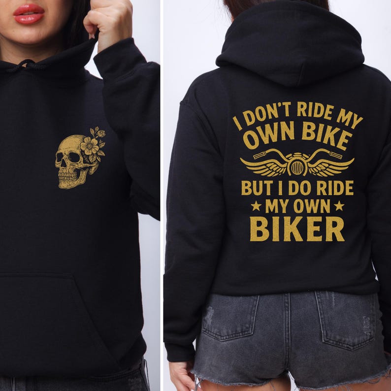 Puede incluir: Sudadera con capucha negra con un dise&ntilde;o de calavera y flores doradas en la parte delantera. La parte trasera de la sudadera con capucha presenta el texto "I DON'T RIDE MY OWN BIKE BUT I DO RIDE MY OWN BIKER" en letras doradas. La sudadera tiene capucha y bolsillo delantero.